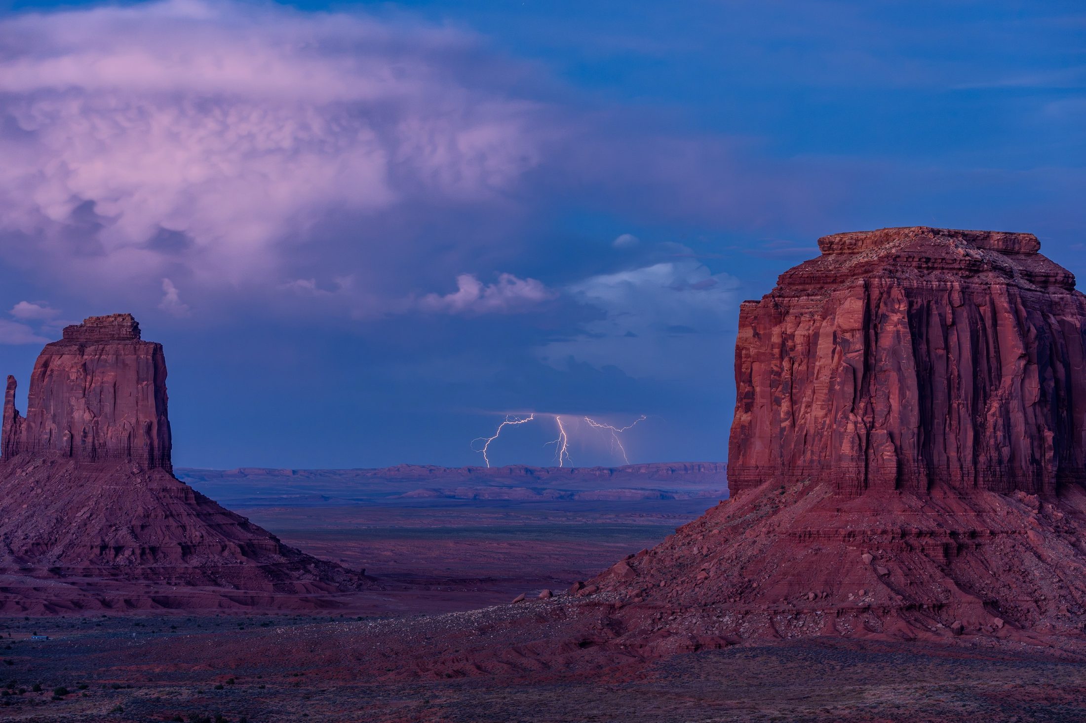 Lightning between the monumental sandstone buttes of Monument Valley